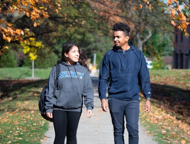 Two Mercy University students walking and talking on the Westchester Campus