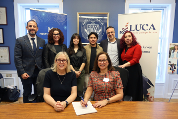 Mercy University and LUCA leadership and students pose at official signing ceremony of new partnership
