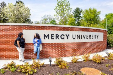 Students in front of Mercy University entrance at the Westchester Campus