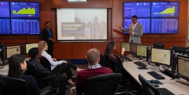Business students presenting in Mercy trading room