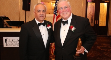 Two men in tuxedos at awards dinner