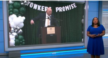 News 12 anchor with Yonkers Promise announcement in the background